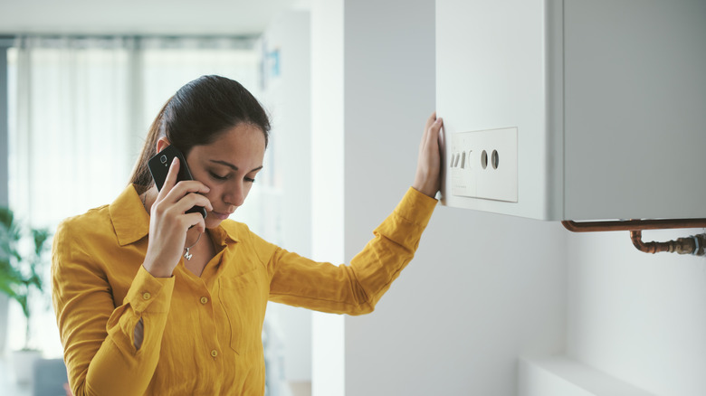 A frustrated woman standing by a furnace