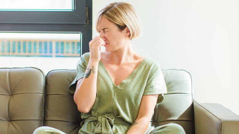 woman holding nose