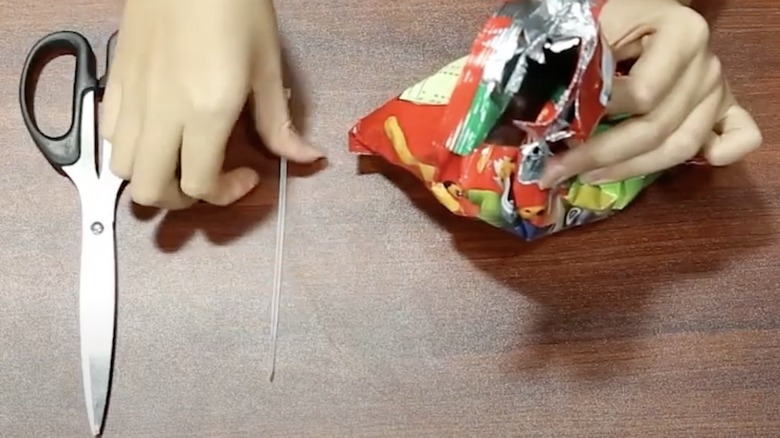 Person making chip clip from zip tie