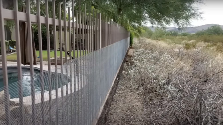 Wire fence with fine mesh on the edge of a house property