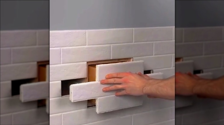 Person opening a hidden drawer from the wall