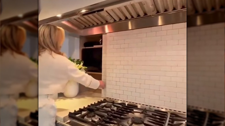 Woman sliding open pocket door in kitchen