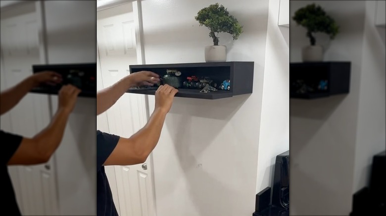 Person opening secret storage compartment in a custom-made wall shelf