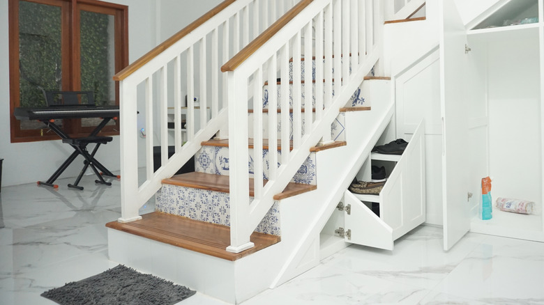 Built-in storage beneath staircase that blends in with the wall