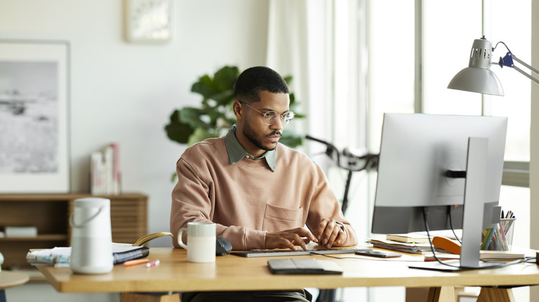 A man working at a generic desk in a home office