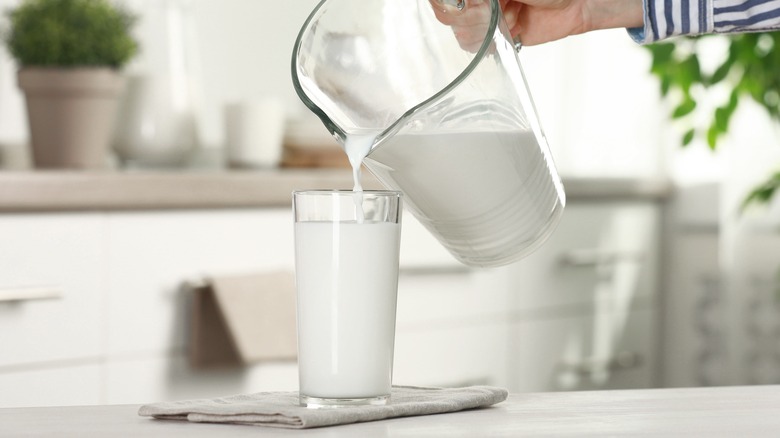 person pouring pitcher of milk