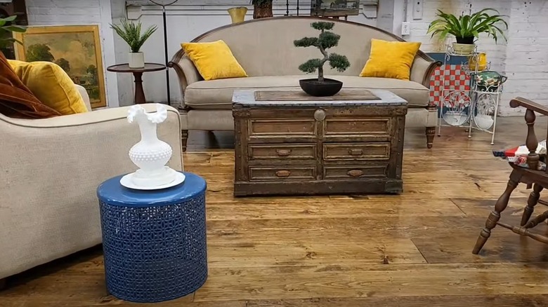 A living room with imitation distressed wood floors, gray sofas, and yellow scatter cushions