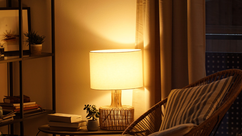 rattan lamp next to bookshelf and chair