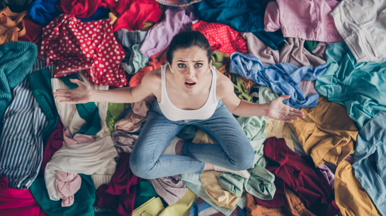 woman sitting on a pile of clothing