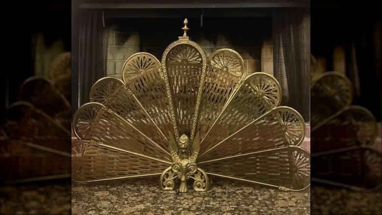 brass antique fireplace screen similar to the shape of a peacock