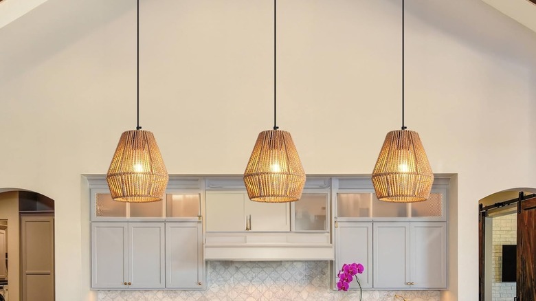 Woven twine pendant lights over white classic kitchen