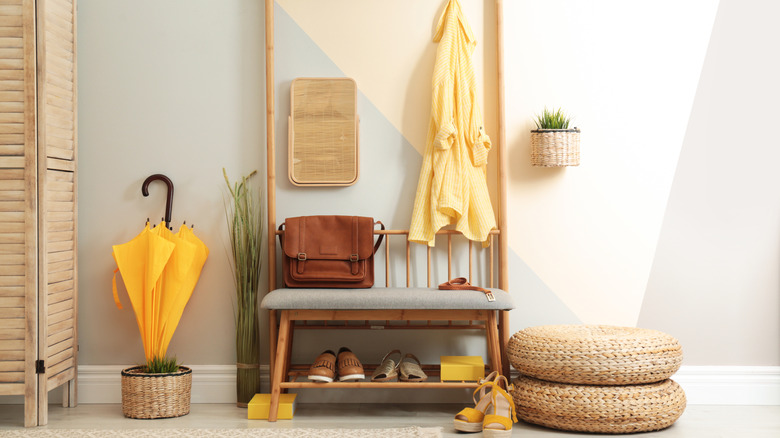 An entryway with folding screen and a bench with shoe storage