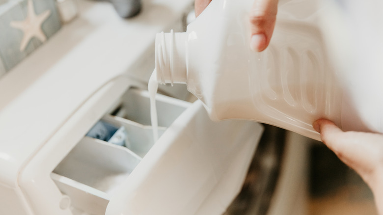 adding detergent to washer