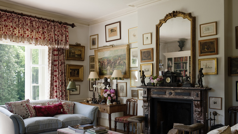 Living room with fireplace, salon-style framed art, and frilly curtains