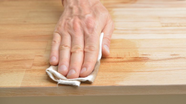 Person rubbing oil into countertops