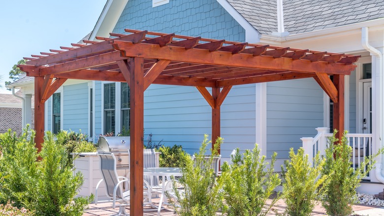 A wooden awning is installed in a backyard