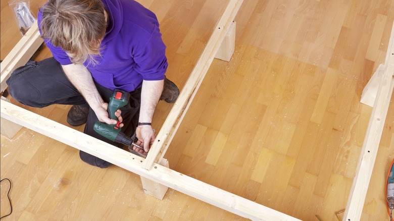 man building bed frame