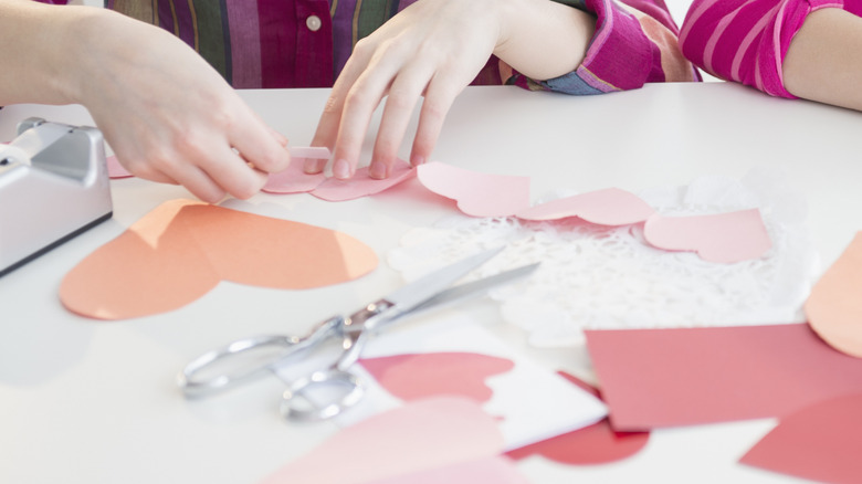 Person cutting out hearts to make Valentine's Day decorations