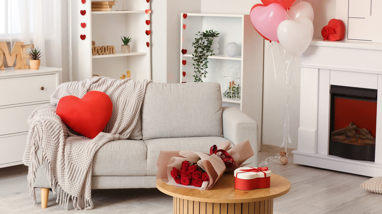 A modern living room is decorated with pink, red, and white hearts for Valentine's Day