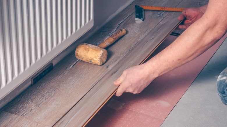 Person putting down wood floorboards