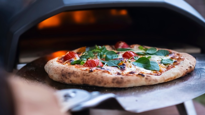 Pizza going into a pizza oven