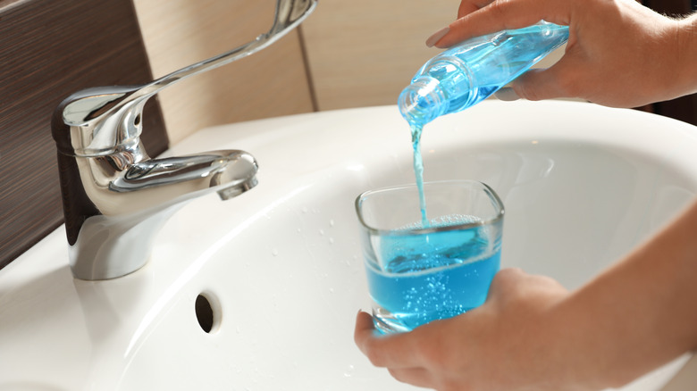 person pouring mouthwash