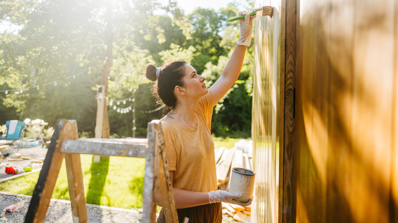 woman painting shed