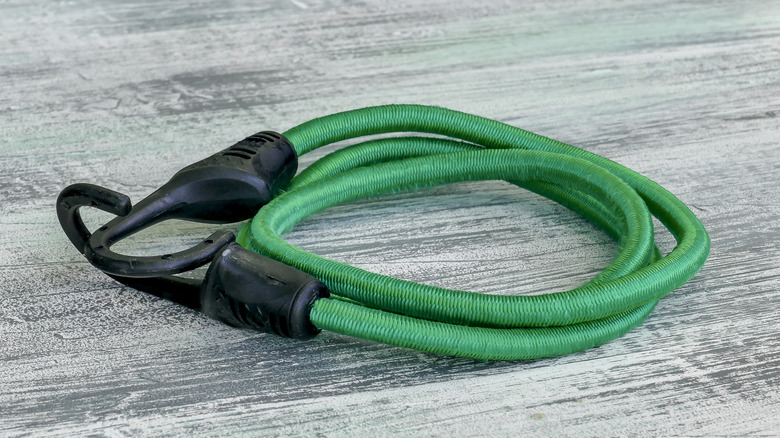 A green bungee cord with black hooks