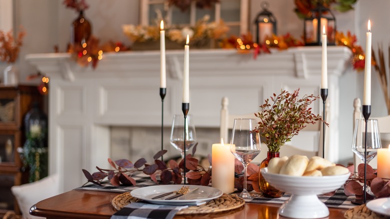 Festive fall tablescape with decorated mantel in the background