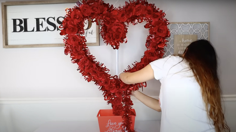 girl wrapping tinsel around her jumbo heart