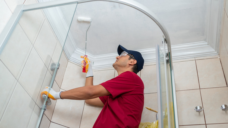 man painting shower ceiling