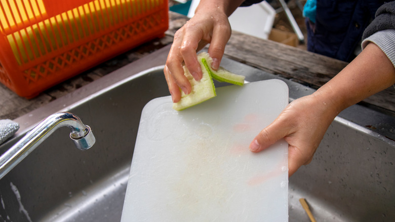 Person cleaning cutting board