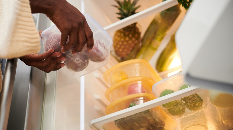 Putting food container in organized refrigerator