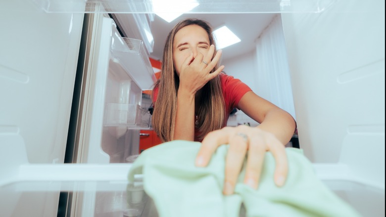 Girl cleaning smelly refridgerator