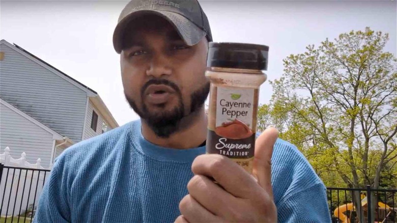 Man holding cayenne pepper container
