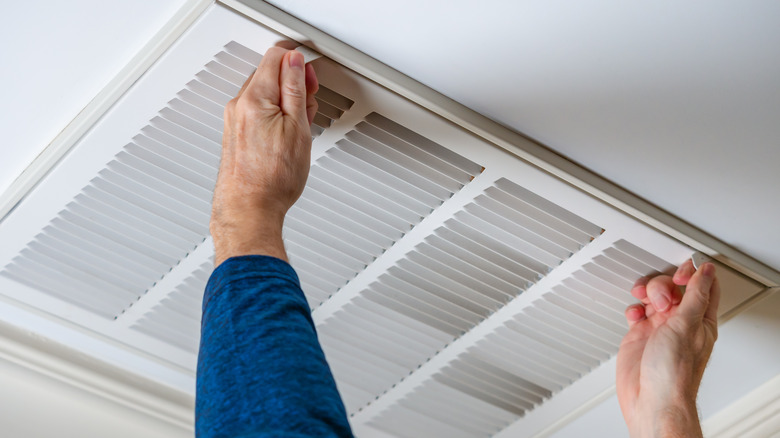 Person removing air vent cover