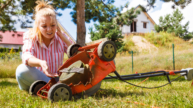 Woman with broken lawn mower