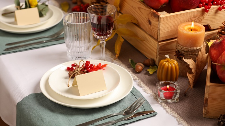 Thanksgiving dinner table with blank place cards on white plates