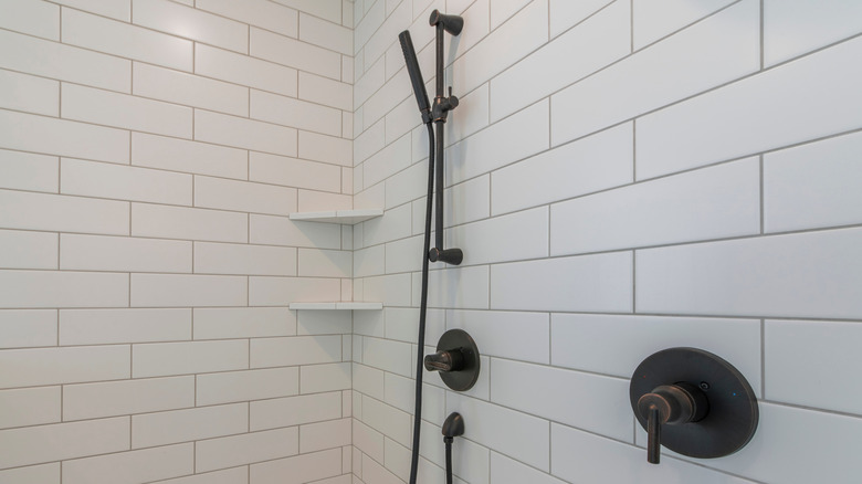 Triangular shower shelves in a shower with subway tiles