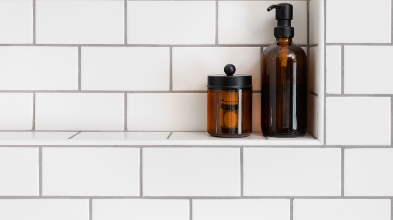 Shower shelf with assorted bottles.