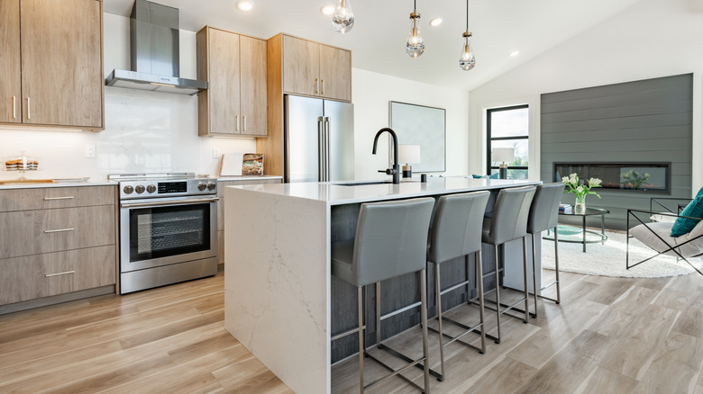 A bright and modern kitchen with blond wood cabinets and an island