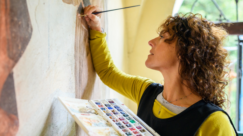 woman paints a wall mural