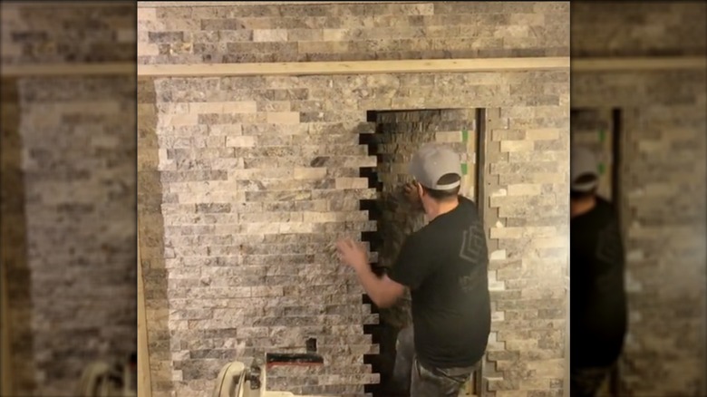 man showing secret brick door