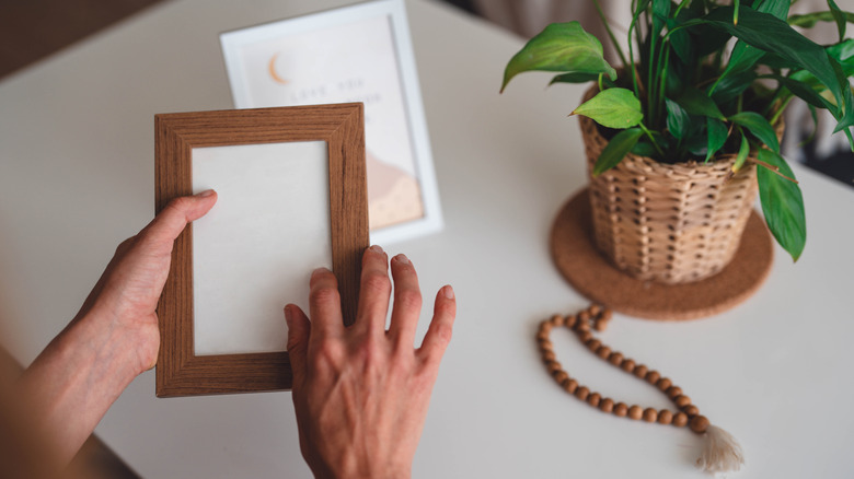 person holding small picture frame