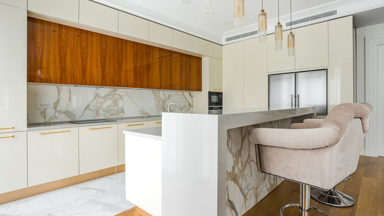 Kitchen interior with brown cabinets, tiled backsplash and a seat