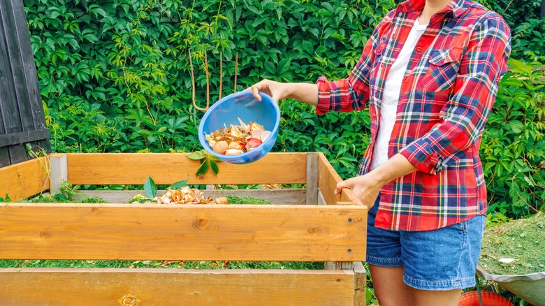 woman adding food scraps to a compost bin