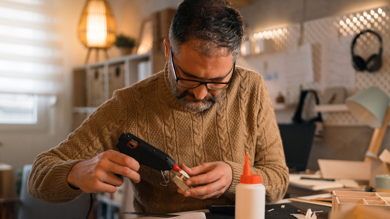 Man using hot glue gun for DIY project