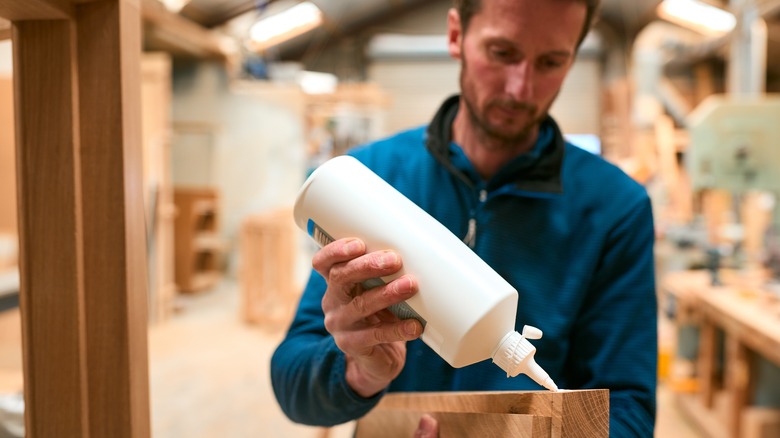 man gluing pieces of wood