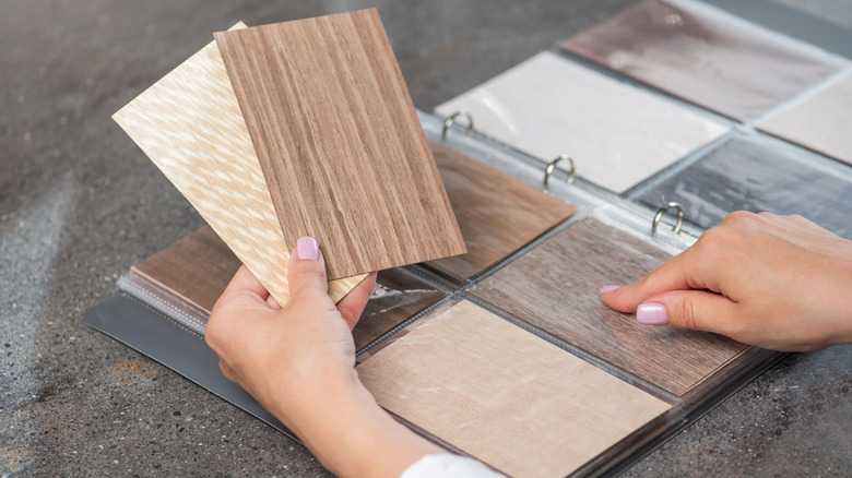 Someone looking through wood flooring samples