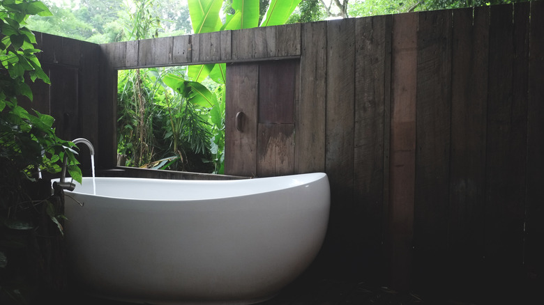 outdoor bathtub with wooden wall